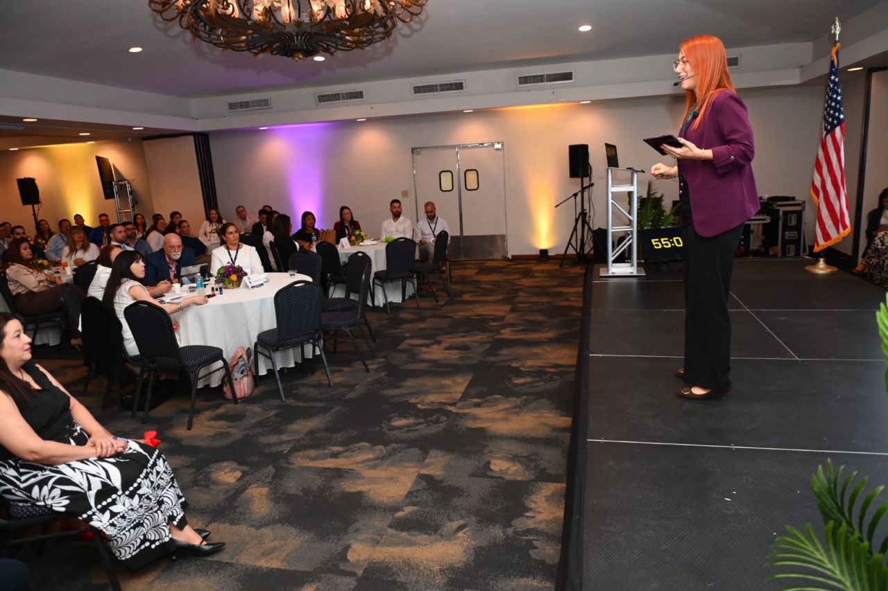 Dra. Mariluz Serrano Ortiz presenta ante participantes reunidos en un auditorio.